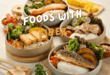 Healthy meals The Best Foods with Fiber for Better Digestion and Health in bowls featuring rice, leafy greens, grilled fish, tofu, and vegetables, arranged on a wooden table.